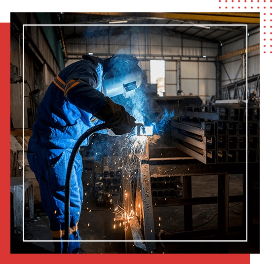 A person welding in an industrial setting with red border.